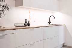 Tammitaso tuo lämpöä valkoiseen kodinhoitohuoneeseen