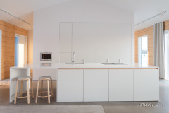 Minimalistinen keittiö upean hirsitalon keskellä