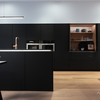 Tunnelmallinen musta keittiö, jossa ripaus tammea tuomassa lämpöä