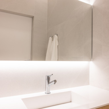 Taustavalaistu seinästä seinään ulottuva peili antaa tasaisen tunnelmavalon koko tilaan