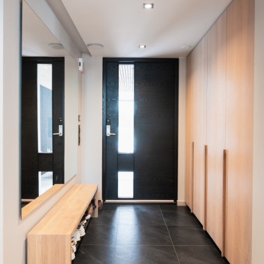 Seinästä seinään ulottuva eteiskaluste tammisilla ovilla ja vetimillä