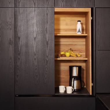 Läpivärjätty musta saarni keittiö tammisella aamiaiskaapilla