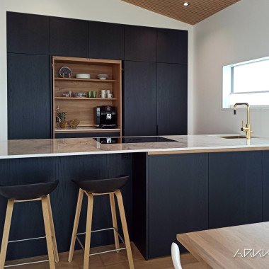 Upea keittiö mustilla ovilla, keraamisella alaslaskeutuvalla tasolla