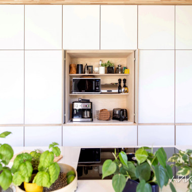 Valkoinen keittiö koivuvanerisella aamiaiskaapilla